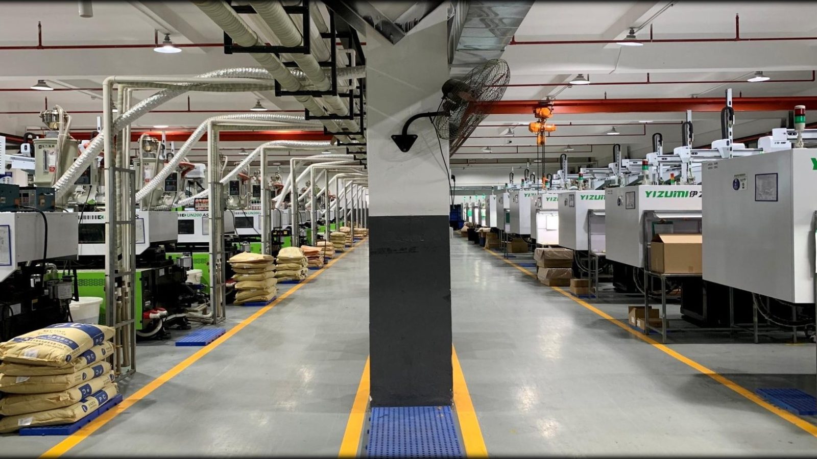 Wide view of the injection molding workshop with overhead material lines