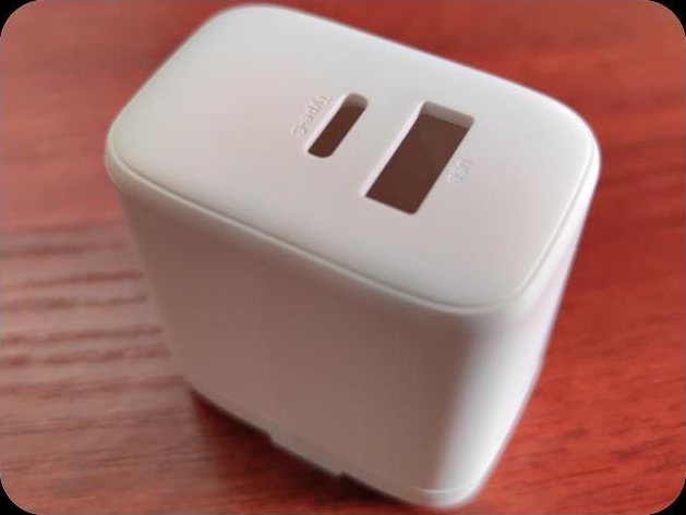 White charger housing with fixed US pins and two port windows on the top face
