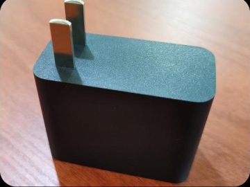 Black rectangular charger housing with fixed two-pin plug and rounded edges