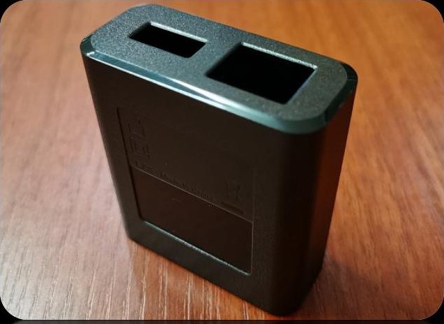 Black wall charger housing with two square port openings and a label recess
