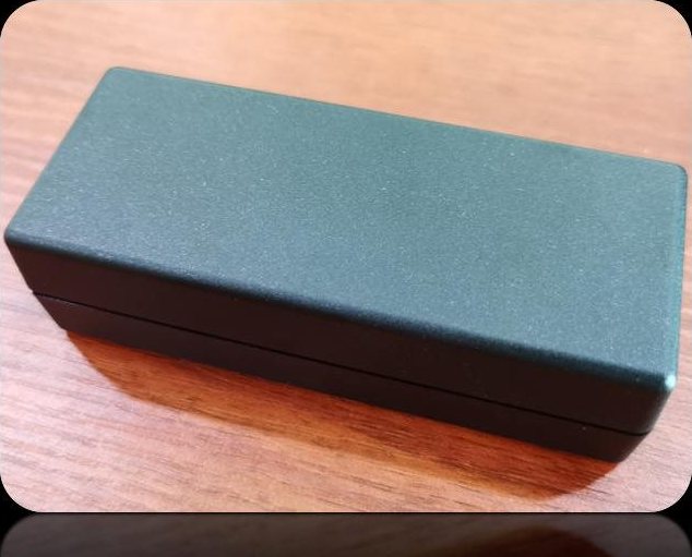 Dark grey desktop adapter enclosure with a fine matte texture