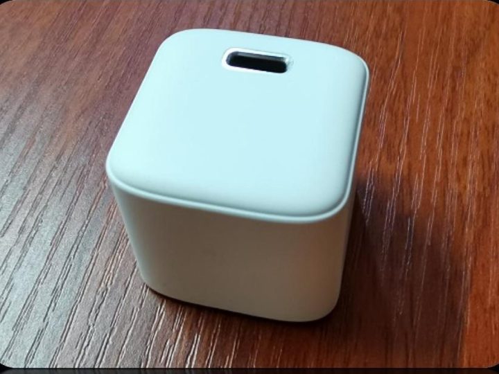 White cube PD charger housing with a small oval port window on the top face